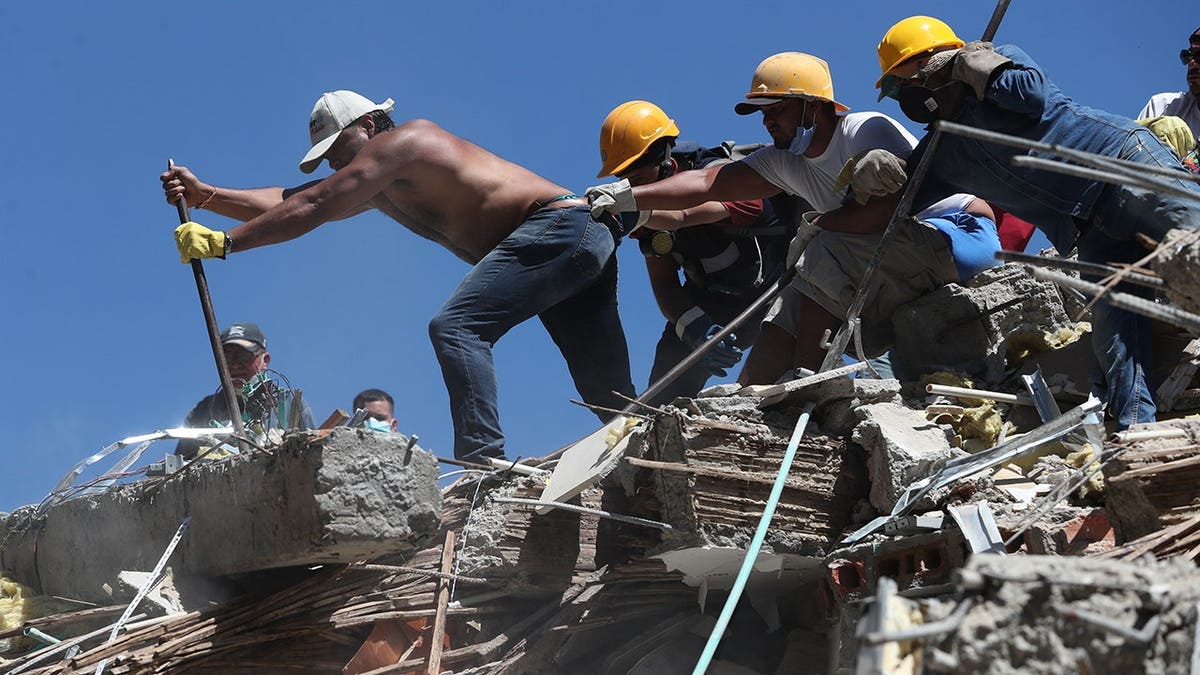 Residents and rescue workers search rubble after an earthquake in Cali, Colombia.