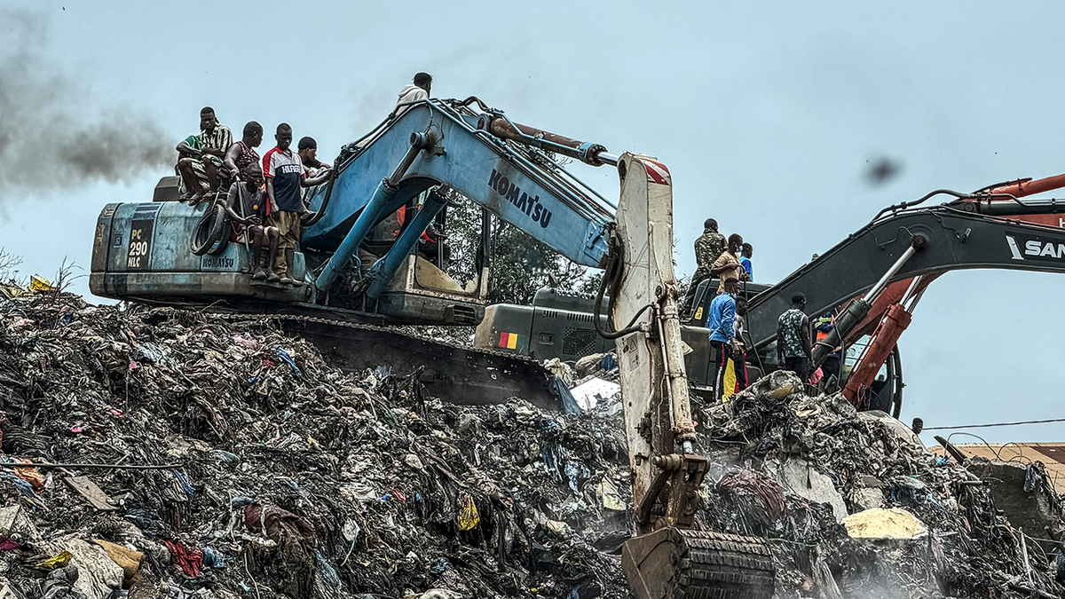 excavator operated by multiple people at landfill