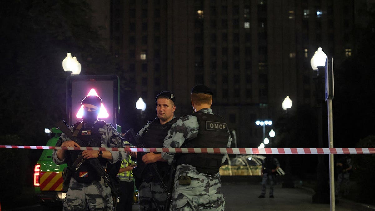 Law enforcement officers stand guard at the site of an explosion in central Moscow.