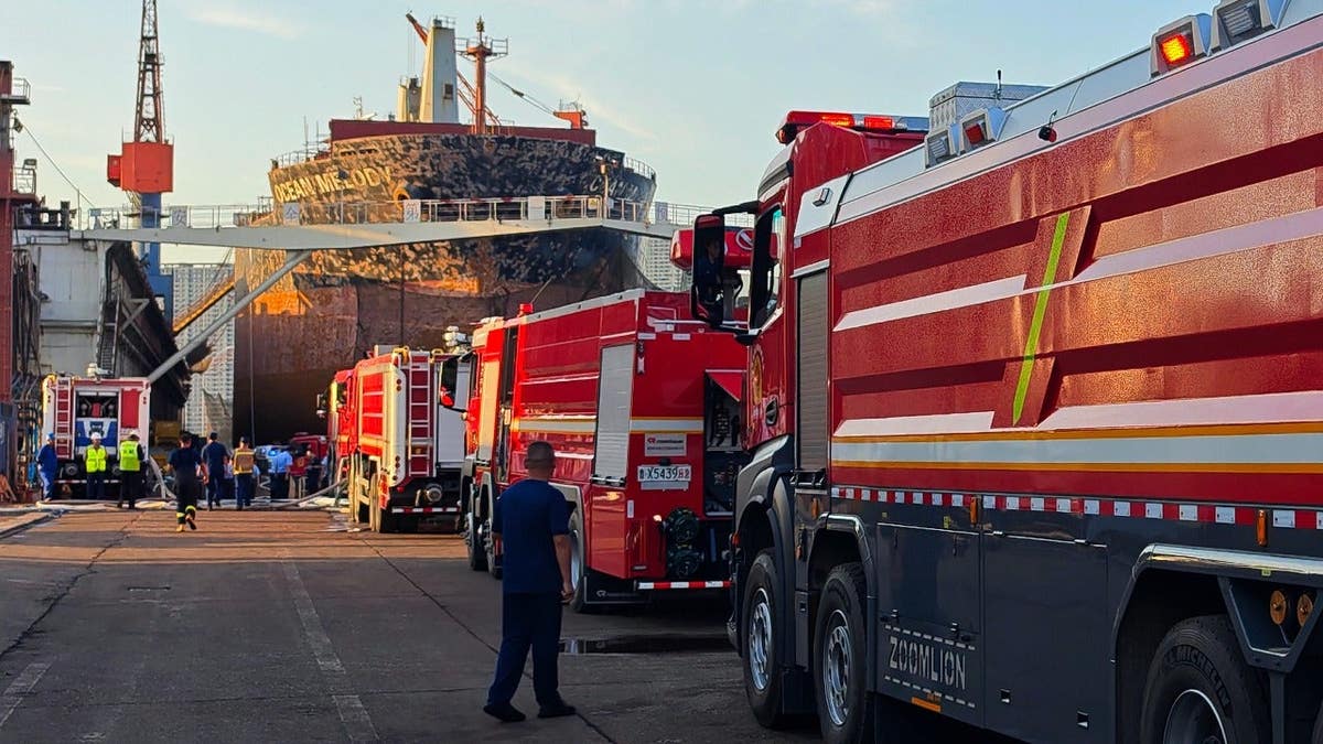 Firefighters and crews gather near the cargo ship