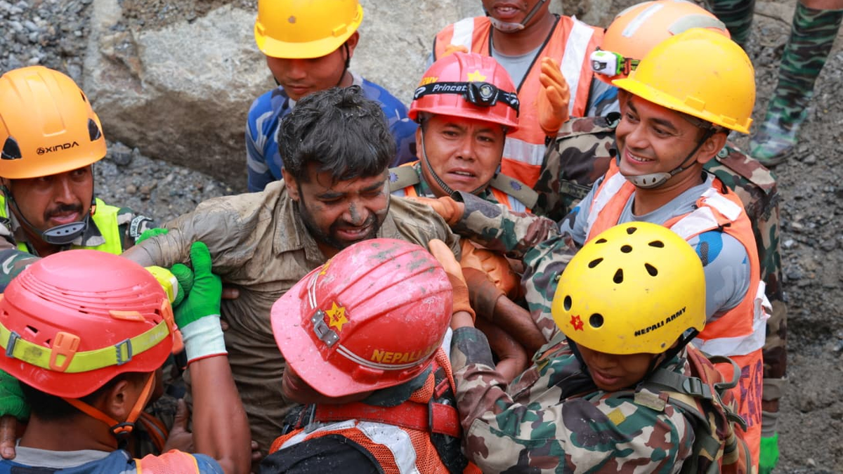 One of the workers is lifted out of the tunnel
