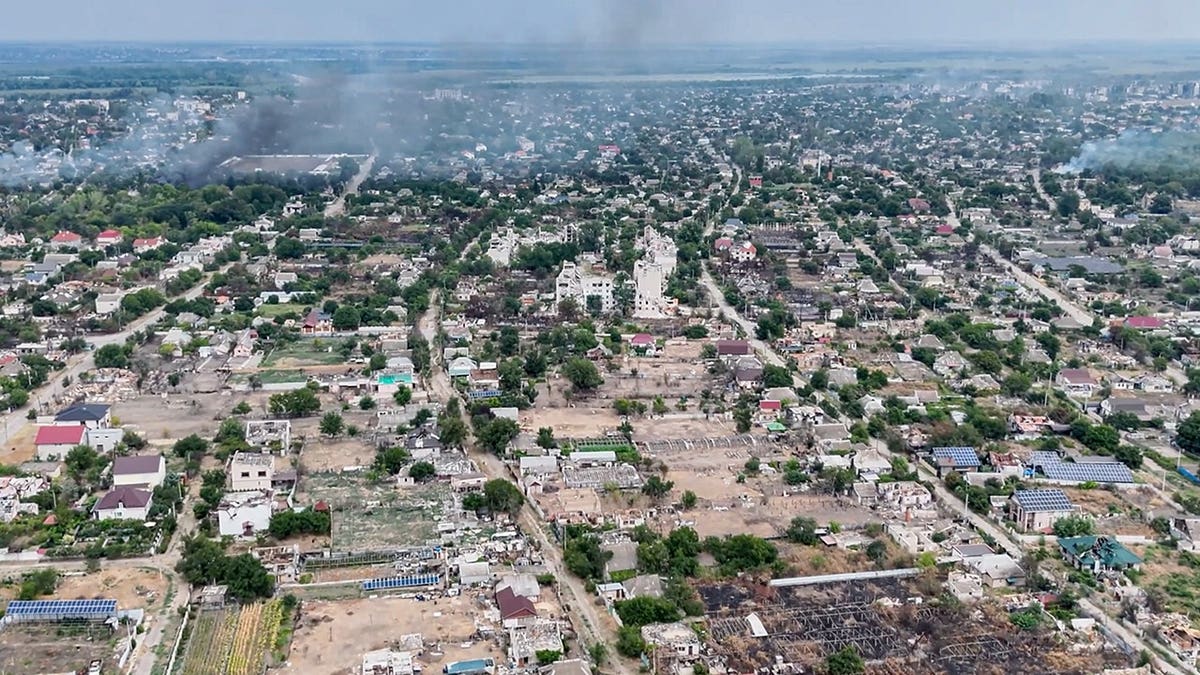 Smoke rises from a residential neighborhood in Oleshky.