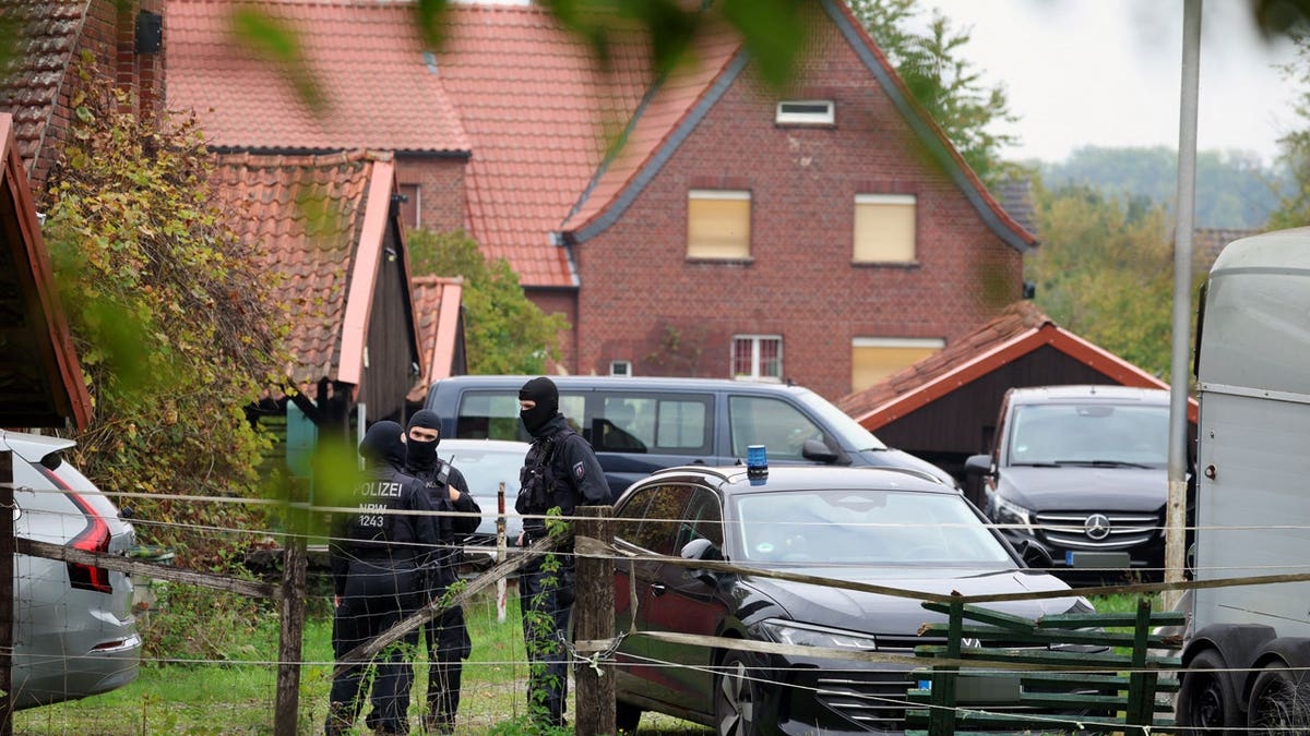 Police officers are standing in front of the home of former president of the Federal Intelligence Service, or BND, August Hanning