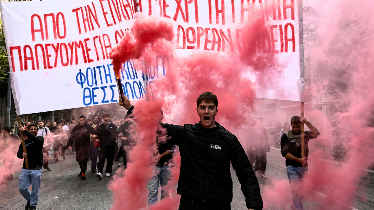 A protester holds a lit flare and shouts slogans as students, teachers and civil servants take part in a rally to protest against the high cost of living, saying they face the same problems that sparked violent demonstrations in France at the weekend, in Greece on October 21, 2026.