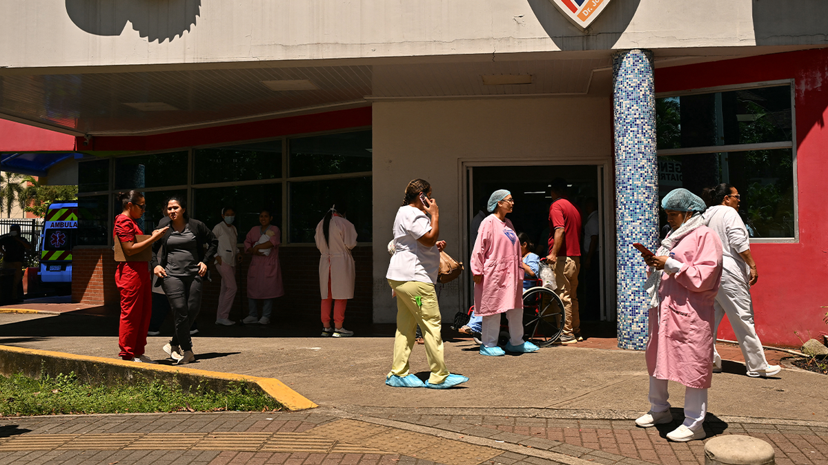 Medical workers and patients stand outside a hospital in Panama following a powerful earthquake