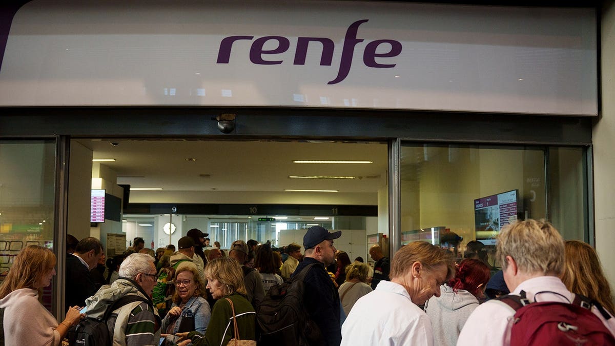 Passengers stand at Santa Justa station in Seville, Spain, following a train accident.